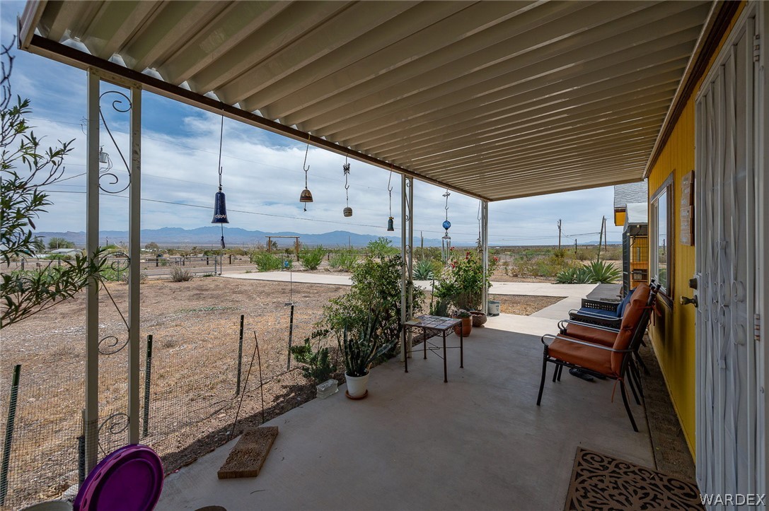 2465 Egar Road Golden Valley, AZ 86413 - Photo 11 of 98 Covered patio with a concrete floor, offering views of the expansive open landscape and distant mountains