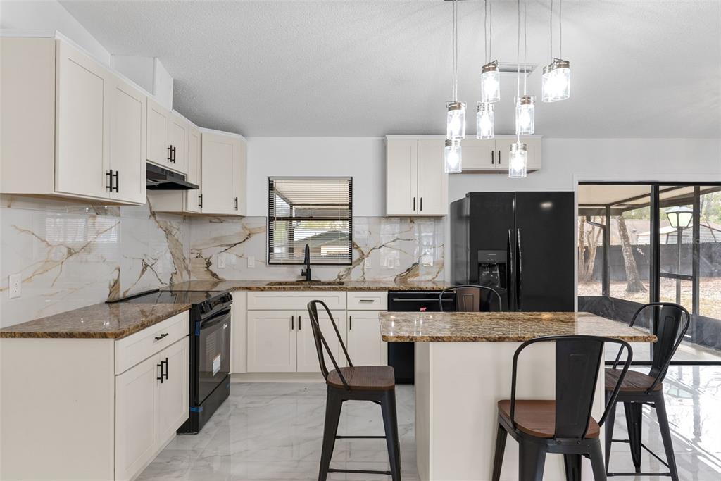 6096 East Tremont Street Inverness, FL 34452 - Photo 15 of 47 a kitchen with stainless steel appliances kitchen island granite countertop a table chairs and a refrigerator