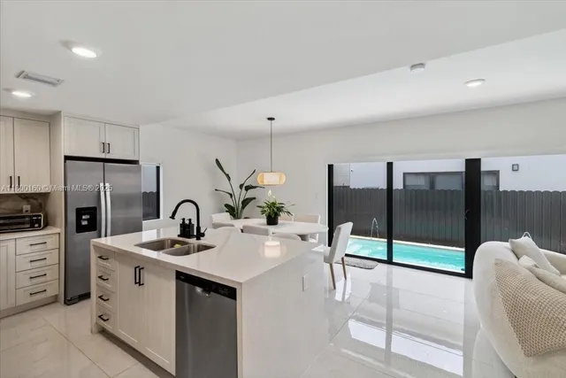 a kitchen with stainless steel appliances kitchen island granite countertop a sink and white cabinets