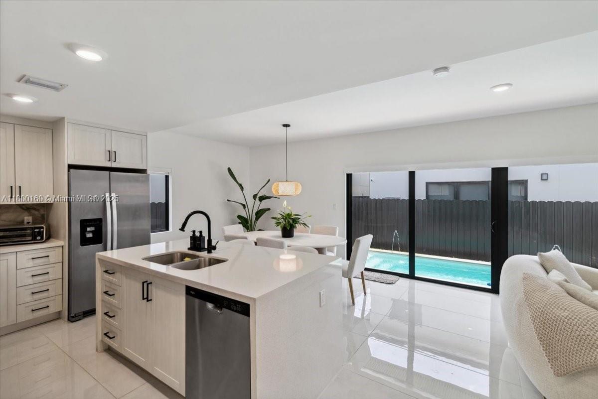 a kitchen with stainless steel appliances kitchen island granite countertop a sink and white cabinets