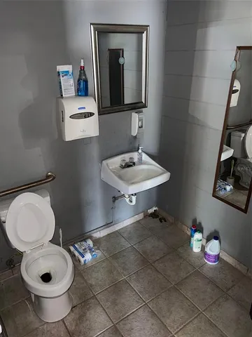a bathroom with a toilet a sink and a mirror