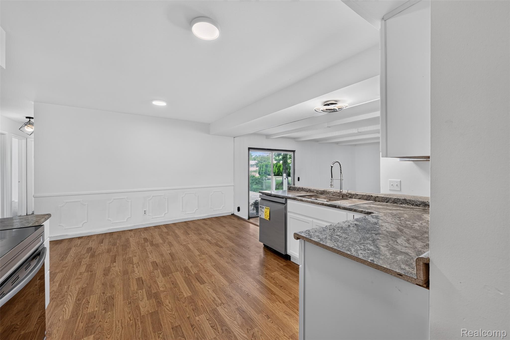 5457 Reid Road Swartz Creek, MI 48473 - Photo 16 of 51 Open-concept kitchen and dining area featuring wood-finish flooring and white walls
