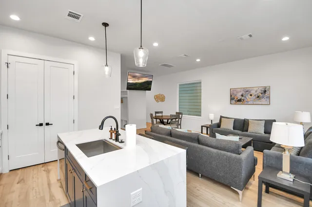 a living room with furniture a sink a window and a flat screen tv