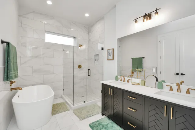 a bathroom with a double vanity sink mirror and bathtub