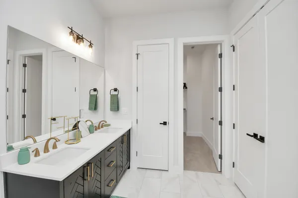 a spacious bathroom with a double vanity sink a mirror and shower