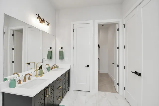 a spacious bathroom with a double vanity sink a mirror and shower