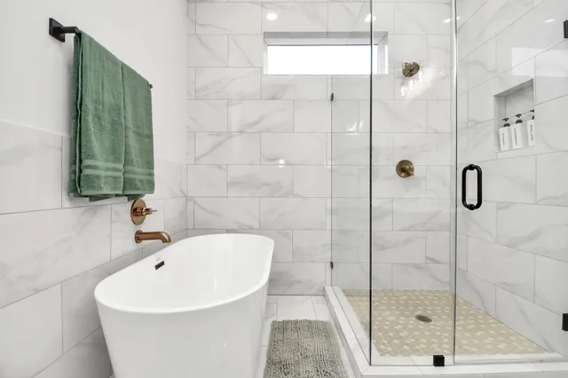a white bath tub sitting next to a shower