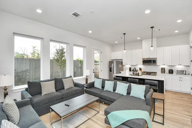 a living room with furniture wooden floor and a view of kitchen