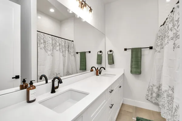a bathroom with double vanity sink and a mirror
