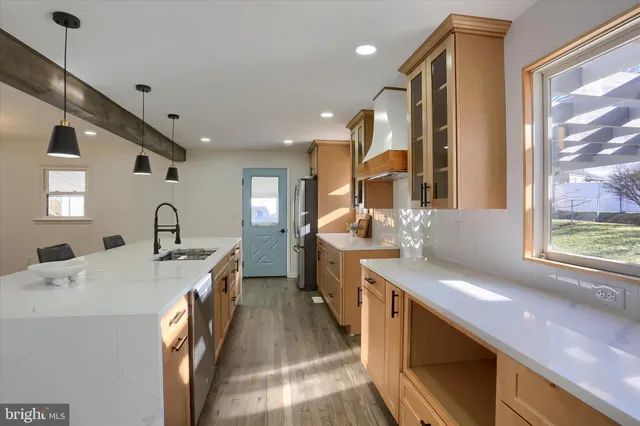 a large kitchen with stainless steel appliances a lot of counter space and a window