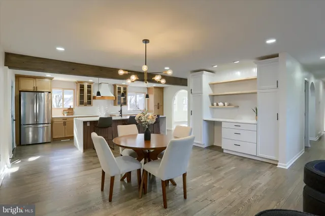 a view of a dining room and livingroom with furniture wooden floor a chandelier