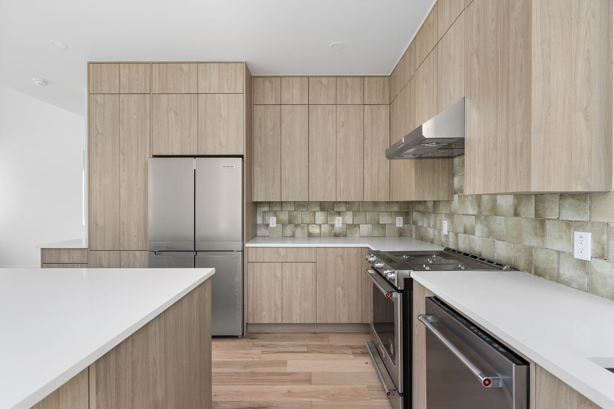 2903 Breeze Terrace, Unit 2 Austin, TX 78722 - Photo 13 of 36 Kitchen featuring stainless steel appliances, light brown cabinets, and exhaust hood