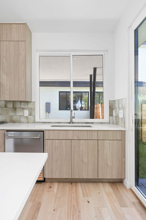 2903 Breeze Terrace, Unit 2 Austin, TX 78722 - Photo 13 of 36 Kitchen with light brown cabinetry, a sink, modern cabinets, dishwasher, and light countertops