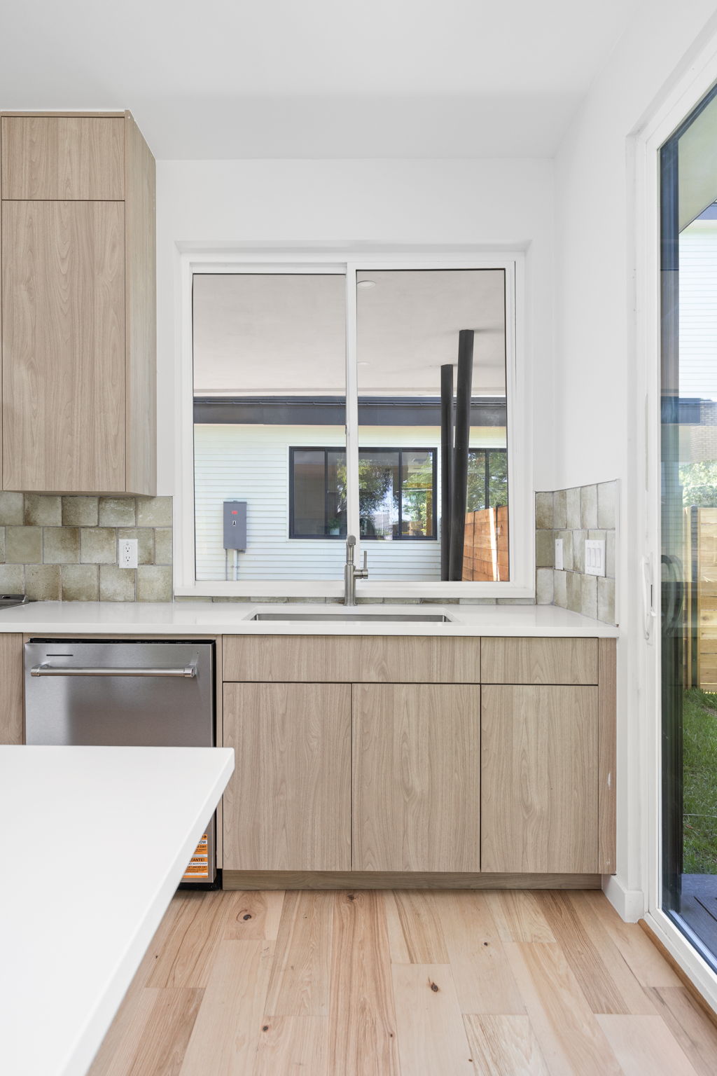2903 Breeze Terrace, Unit 2 Austin, TX 78722 - Photo 15 of 36 Kitchen with light brown cabinetry, a sink, modern cabinets, dishwasher, and light countertops