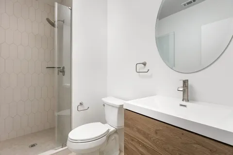 a bathroom with a sink a toilet and a mirror