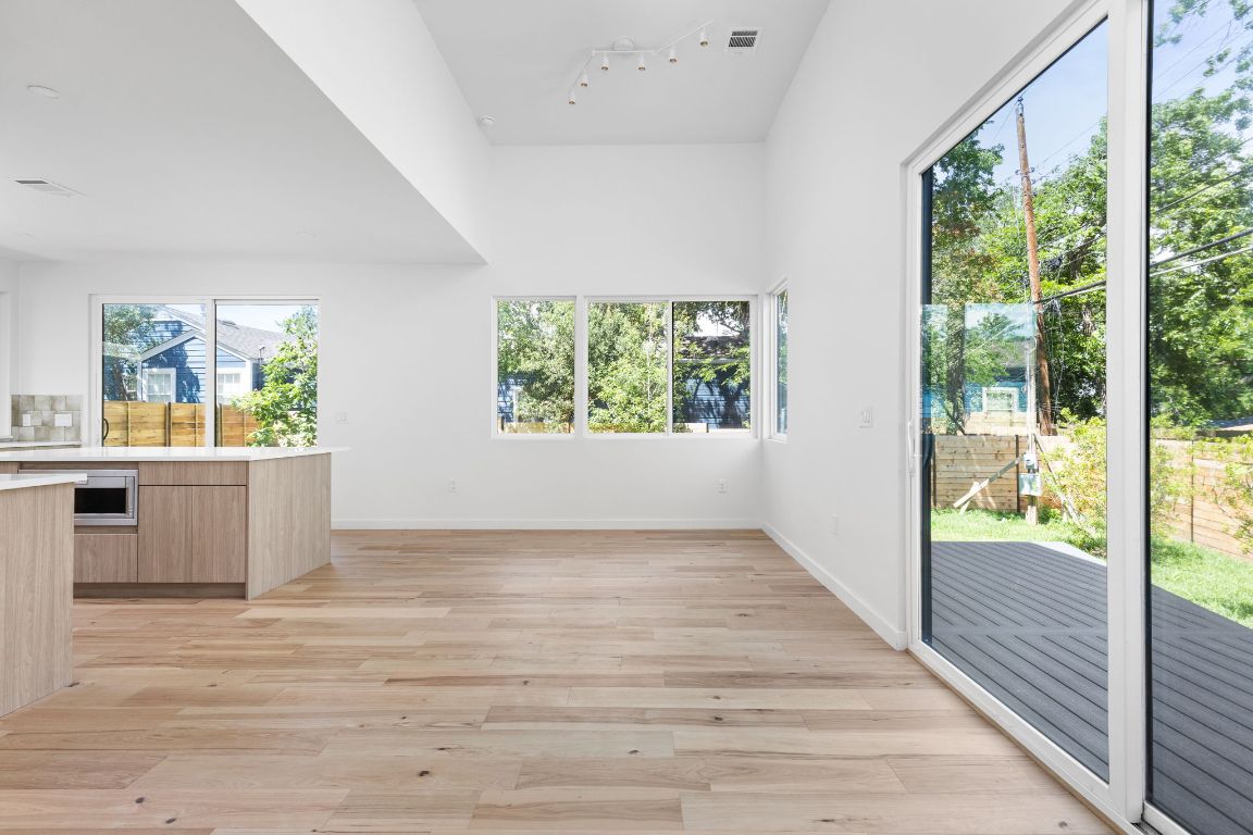2903 Breeze Terrace, Unit 2 Austin, TX 78722 - Photo 7 of 36 Unfurnished dining area featuring track lighting, light wood-type flooring, and baseboards