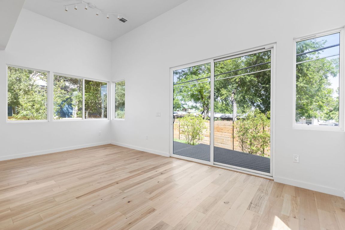 2903 Breeze Terrace, Unit 2 Austin, TX 78722 - Photo 8 of 36 Unfurnished room featuring healthy amount of natural light, light wood-style floors, rail lighting, and baseboards
