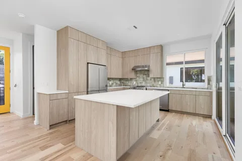 a large kitchen with a lot of counter space and wooden floor