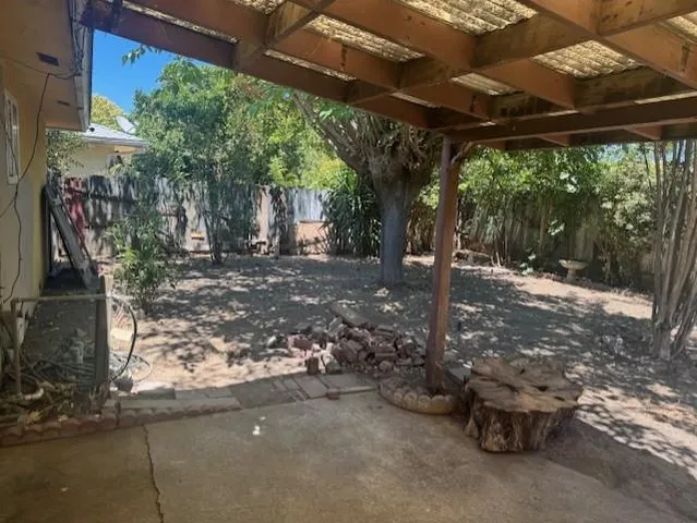a view of a patio with table and chairs potted plants