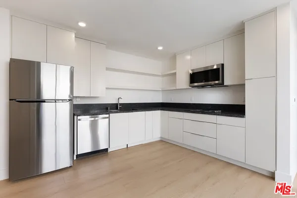 a kitchen with appliances a sink and a counter top space