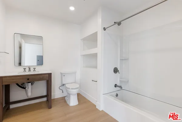 a bathroom with a granite countertop sink a toilet and shower