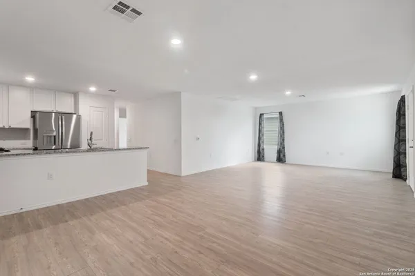 a view of an empty room with kitchen appliances