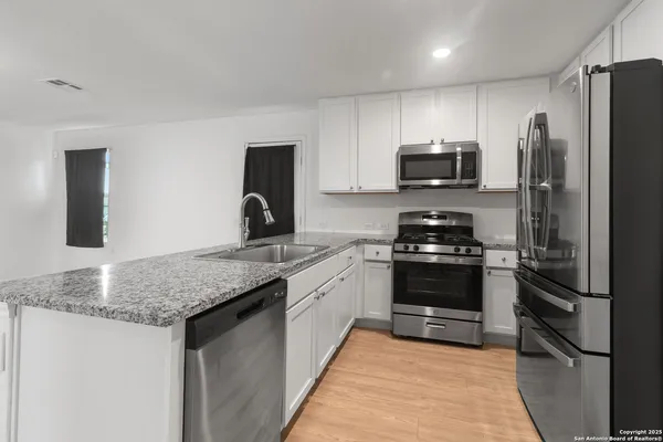 a kitchen with stainless steel appliances granite countertop a refrigerator sink and stove