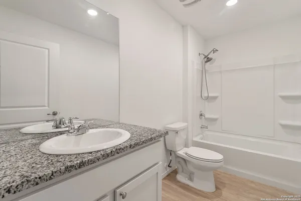 a bathroom with a granite countertop sink toilet a mirror and shower