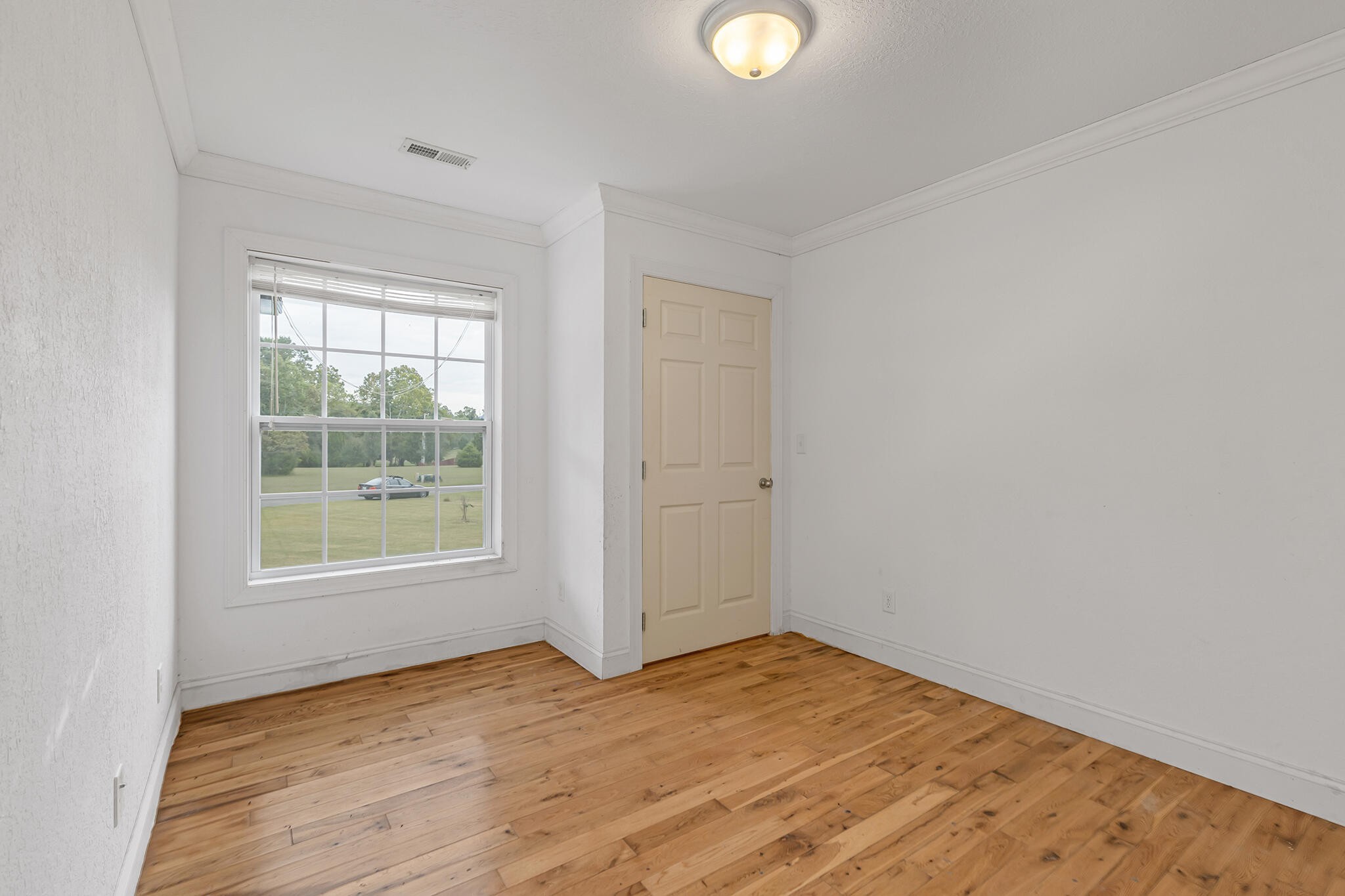 173 Hidden Meadow Lane Dunlap, TN 37327 - Photo 10 of 22 an empty room with wooden floor and windows