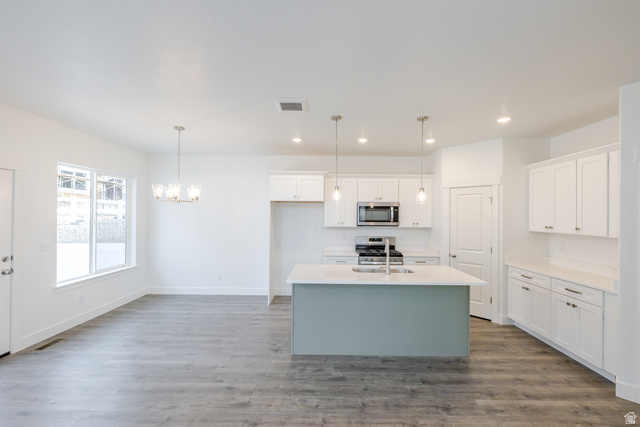 4769 Olive Avenue, Unit 411 Mapleton, UT 84664 - Photo 2 of 19 Kitchen with a kitchen island with sink, two tone color scheme, stainless steel appliances, dark wood-style floors, and suspended lighting