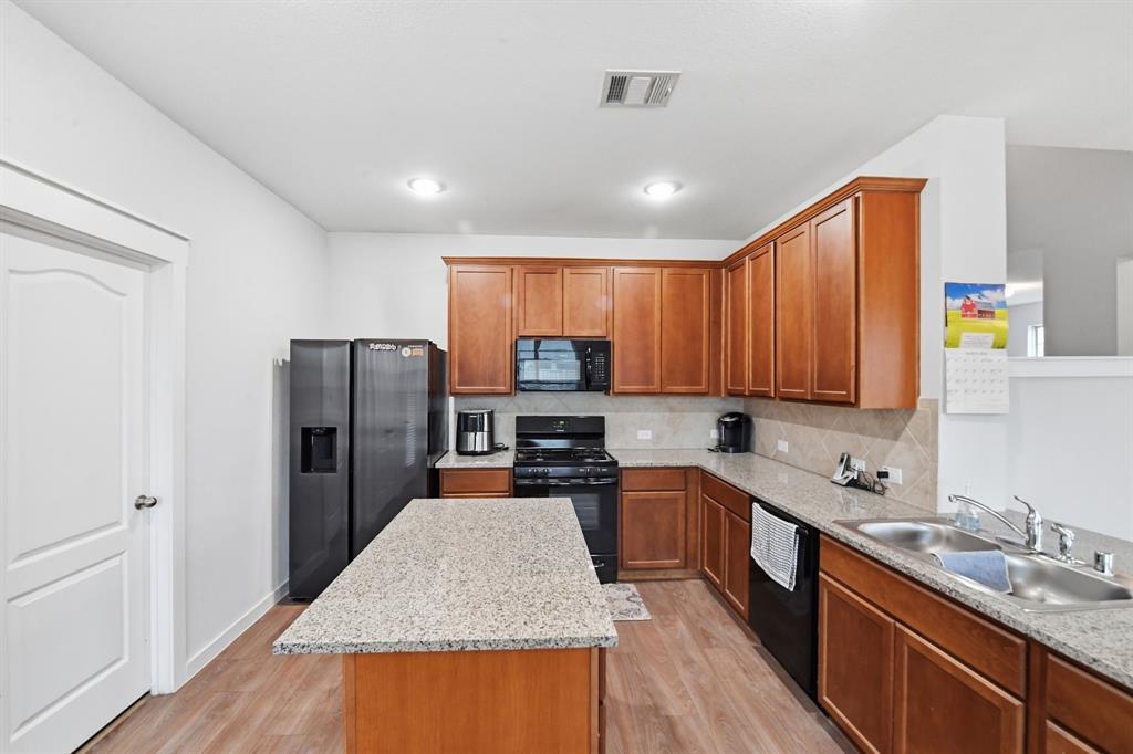 4228 Bullock Lane Forney, TX 75126 - Photo 20 of 40 a kitchen with refrigerator a sink and cabinets