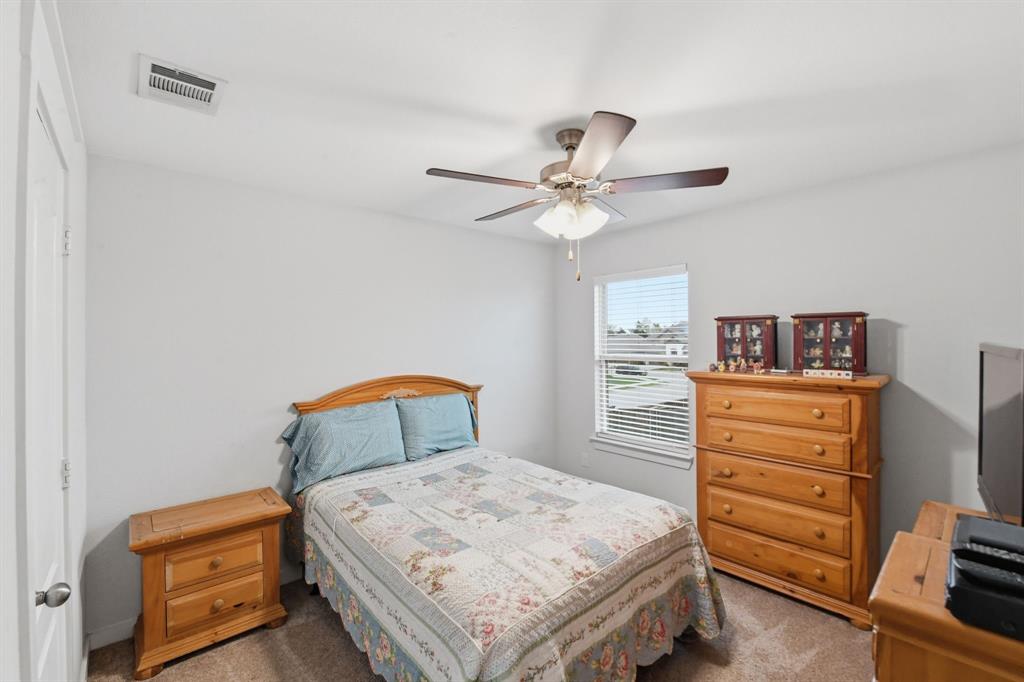 4228 Bullock Lane Forney, TX 75126 - Photo 30 of 40 a bedroom with a bed a dresser and a chandelier