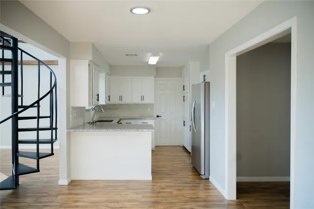 a kitchen with a refrigerator and a stove top oven
