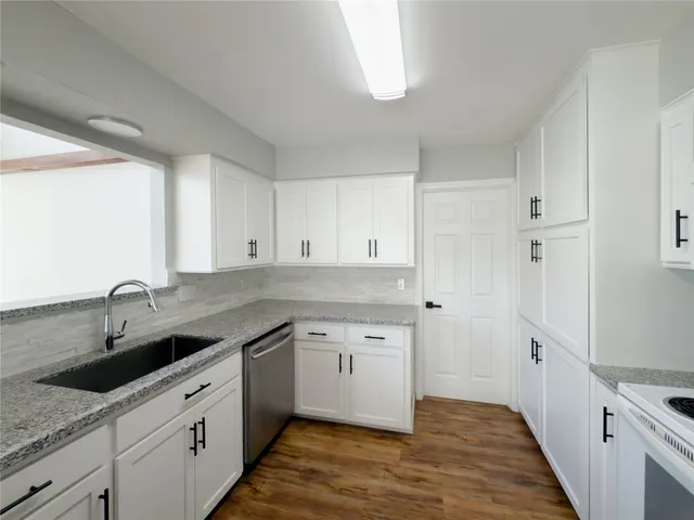 a kitchen with a sink dishwasher and cabinets