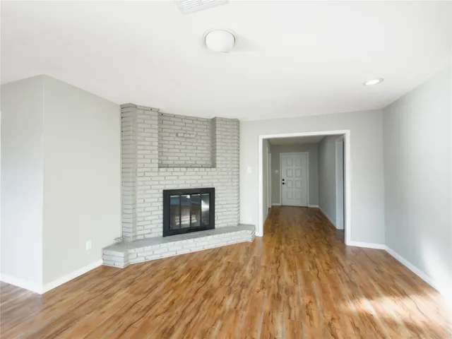 a view of empty room with wooden floor and fireplace