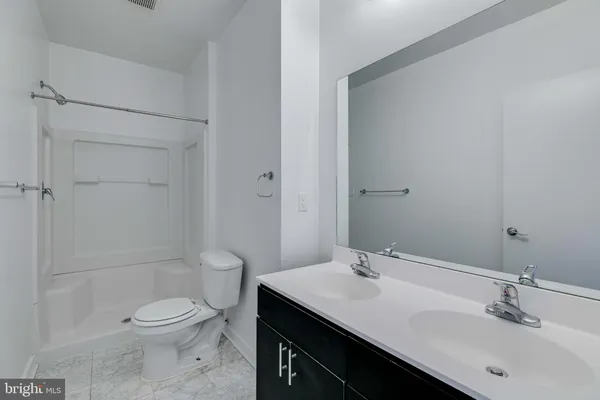 a bathroom with a granite countertop sink a toilet and shower