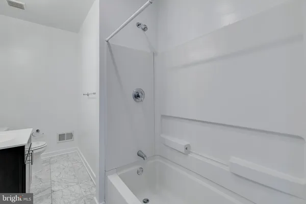a bathroom with a bathtub and a toilet
