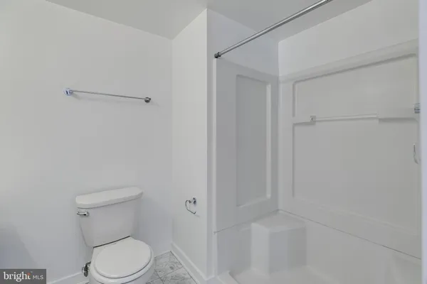 a white toilet sitting next to a shower