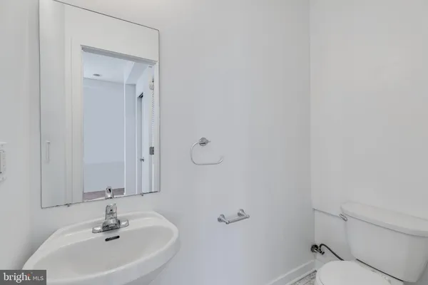 a bathroom with a sink a toilet and a mirror