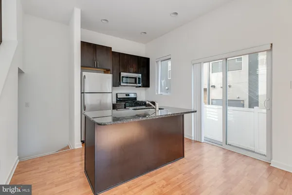 a kitchen with stainless steel appliances granite countertop a refrigerator and a stove top oven