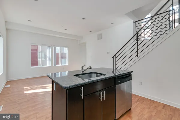 a kitchen with granite countertop kitchen island a sink a stove and a window