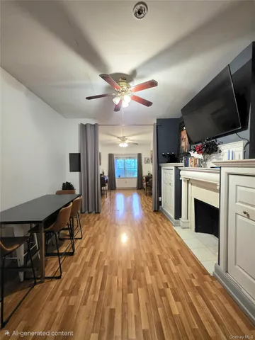 a view of a livingroom with a flat screen tv a fireplace and a ceiling fan