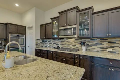 a kitchen with stainless steel appliances granite countertop a sink stove and refrigerator