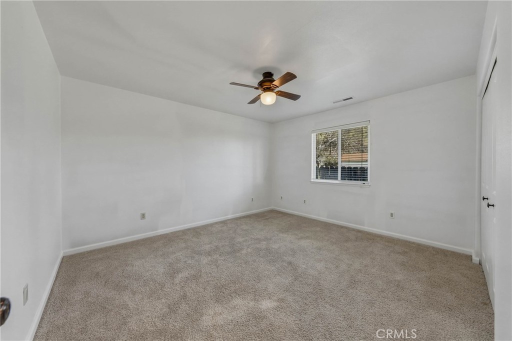 3483 Beach Street Nice, CA 95464 - Photo 17 of 40 an empty room with chandelier fan and windows