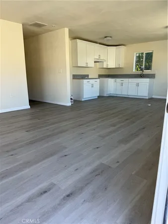 a kitchen with granite countertop wooden cabinets and wooden floor