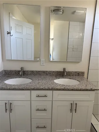 a bathroom with sink granite and white vanity