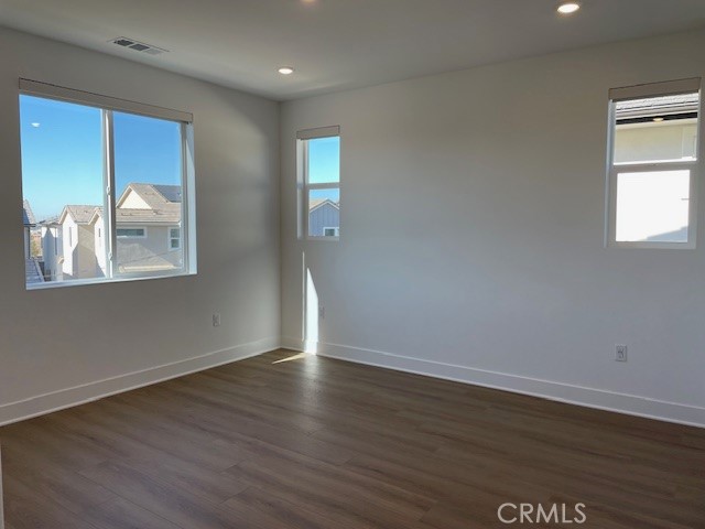 213 Shoveler Irvine, CA 92618 - Photo 12 of 19 a view of an empty room with wooden floor and a window