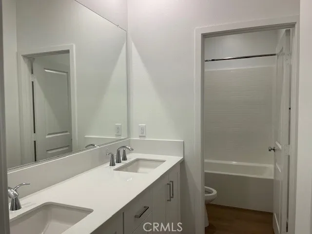 a bathroom with a sink vanity granite tub shower and a mirror