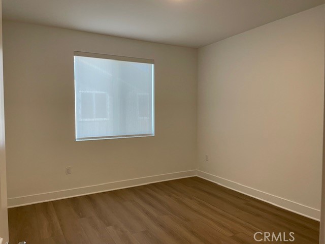 213 Shoveler Irvine, CA 92618 - Photo 10 of 19 a view of an empty room with wooden floor and a window