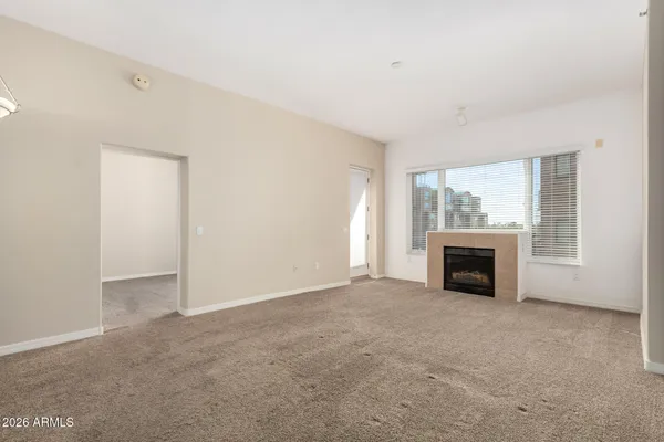 an empty room with fireplace and windows
